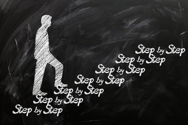 drawing of a man walking up steps.  the steps are made from the phrase step by step.  drawn with white chalk on a black chalkboard