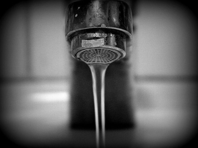close up of a faucet with water streaming out